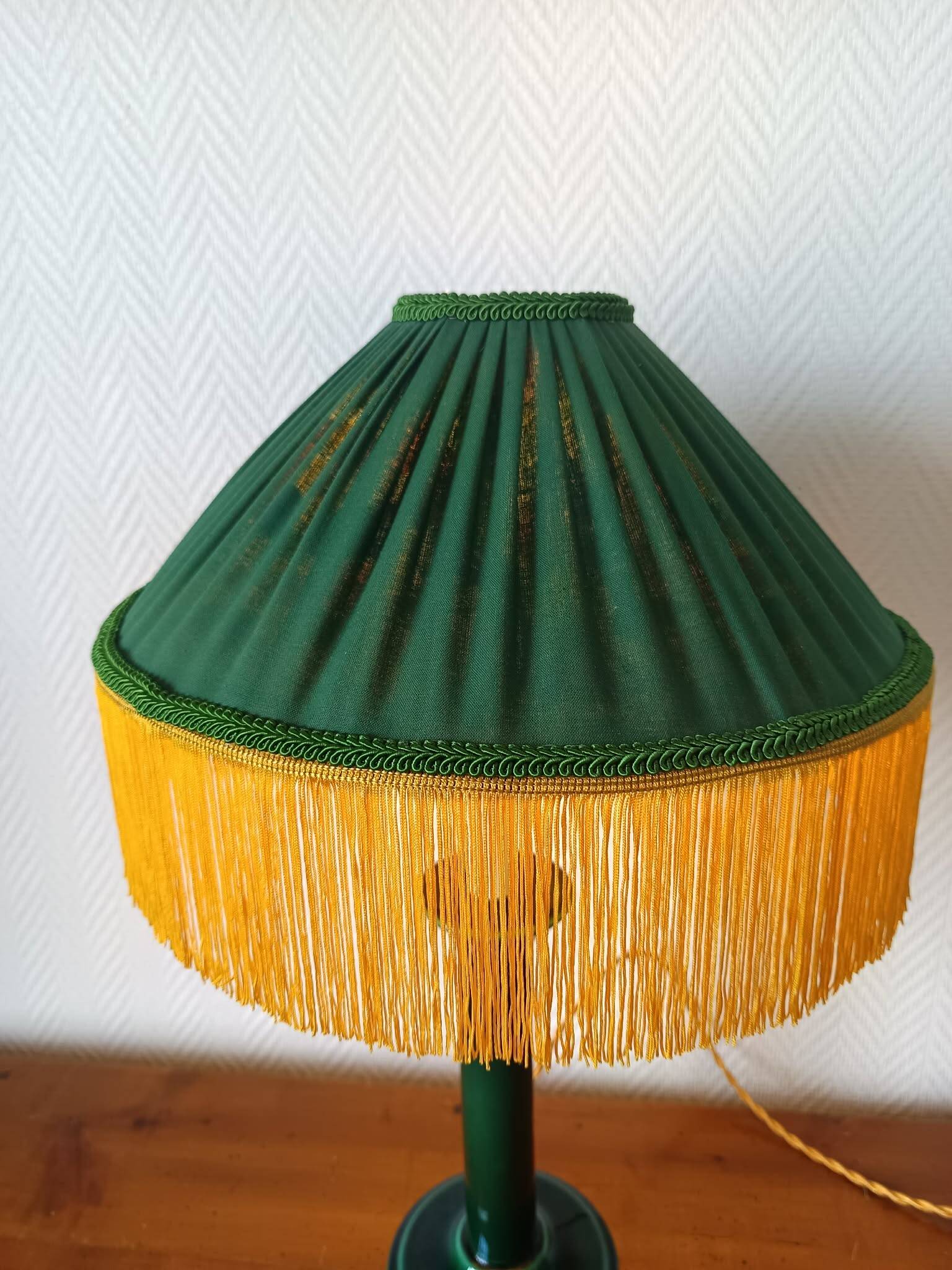 Green ceramic lamp with a vintage pleated fringe shade.