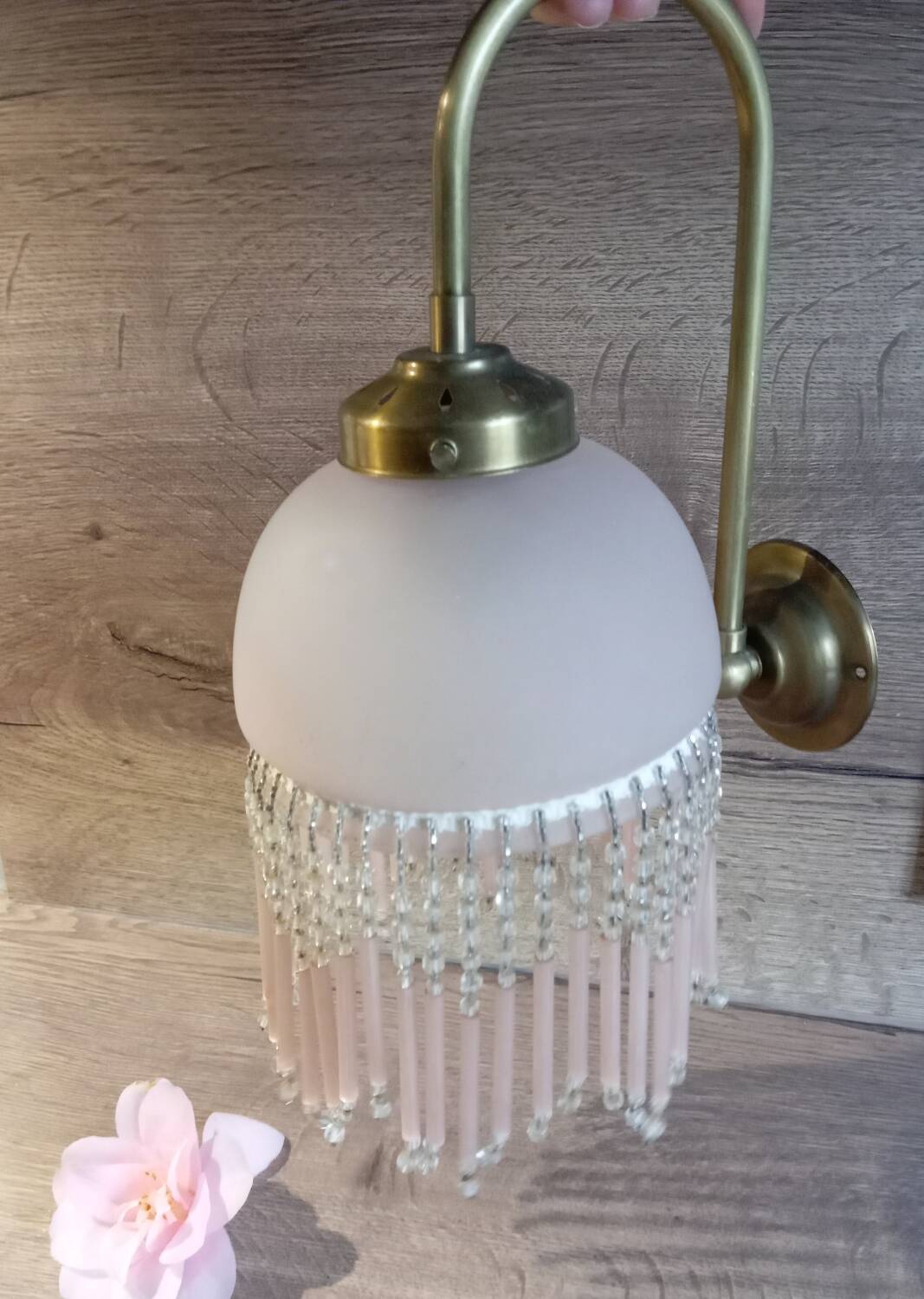 Brass swan neck wall lamp with pink glass globe and Charleston tassels