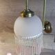 Brass swan neck wall lamp with pink glass globe and Charleston tassels