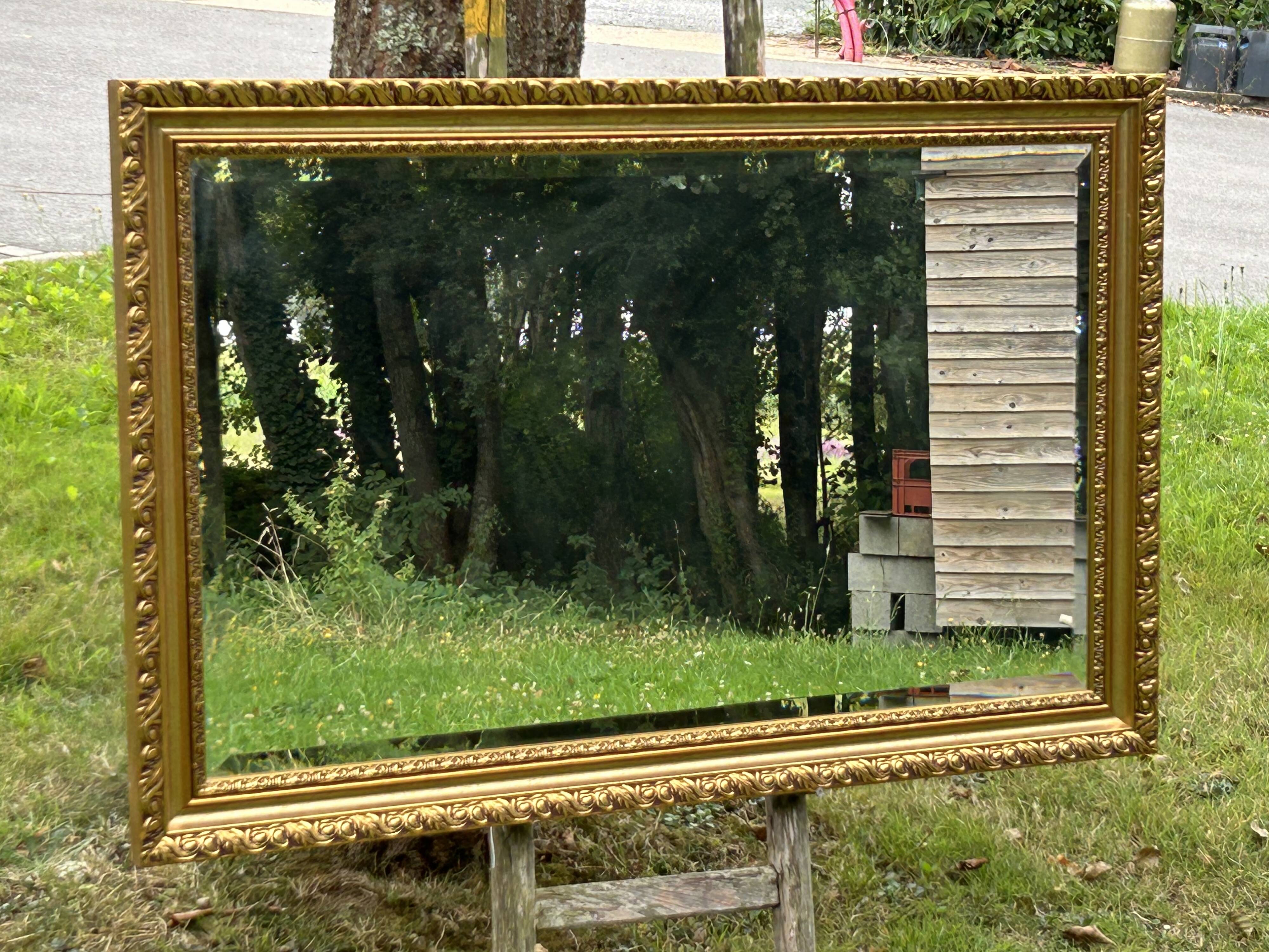 Large beveled mirror in wood and gilded stucco