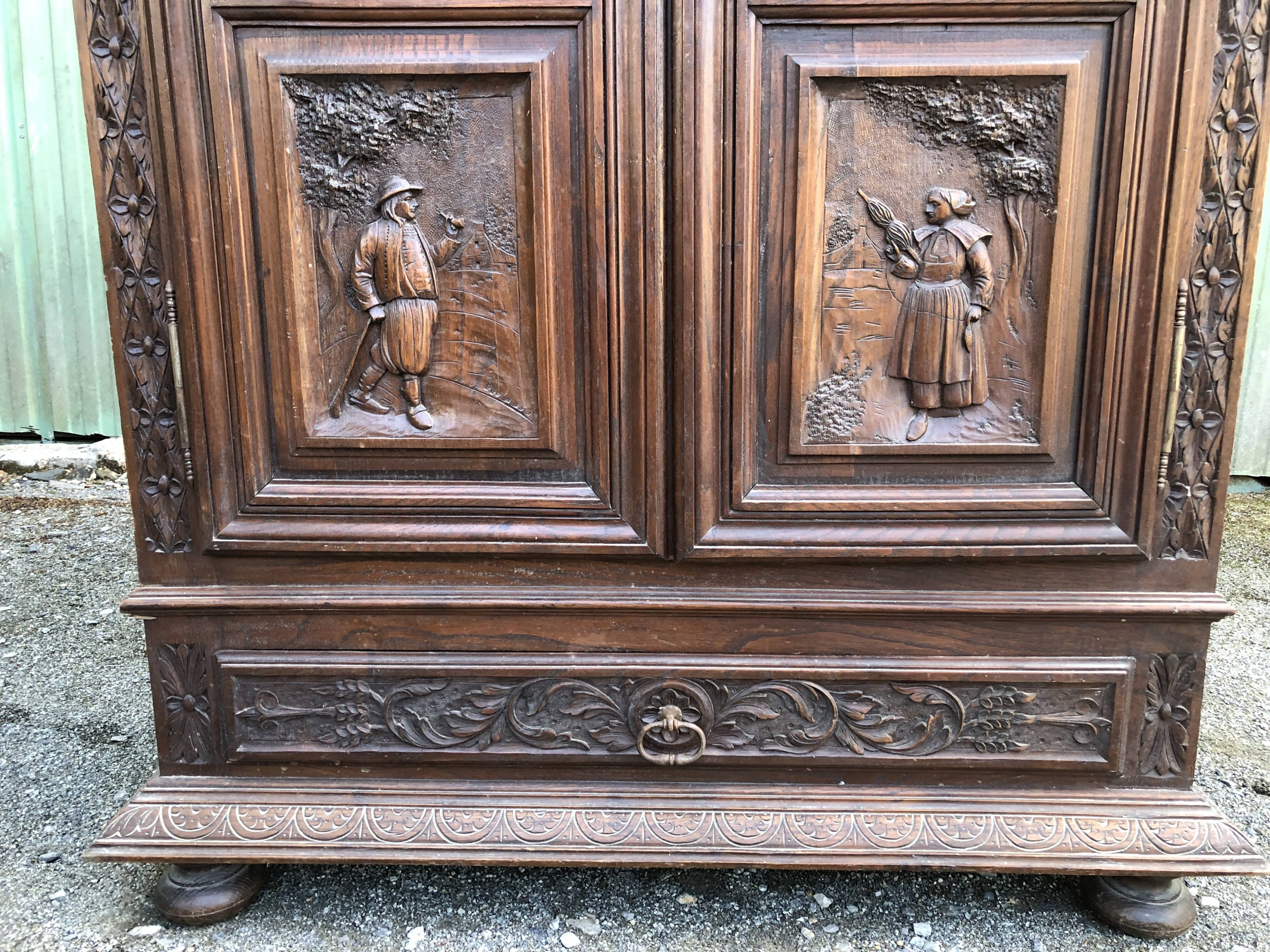 Breton cabinet with carved characters of the early 20th century with 2 doors and 1 oak drawer.