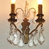 Pair of French antique brass double wall lights with assorted crystals.