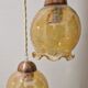 2 iridescent amber luminaires in suspensions
