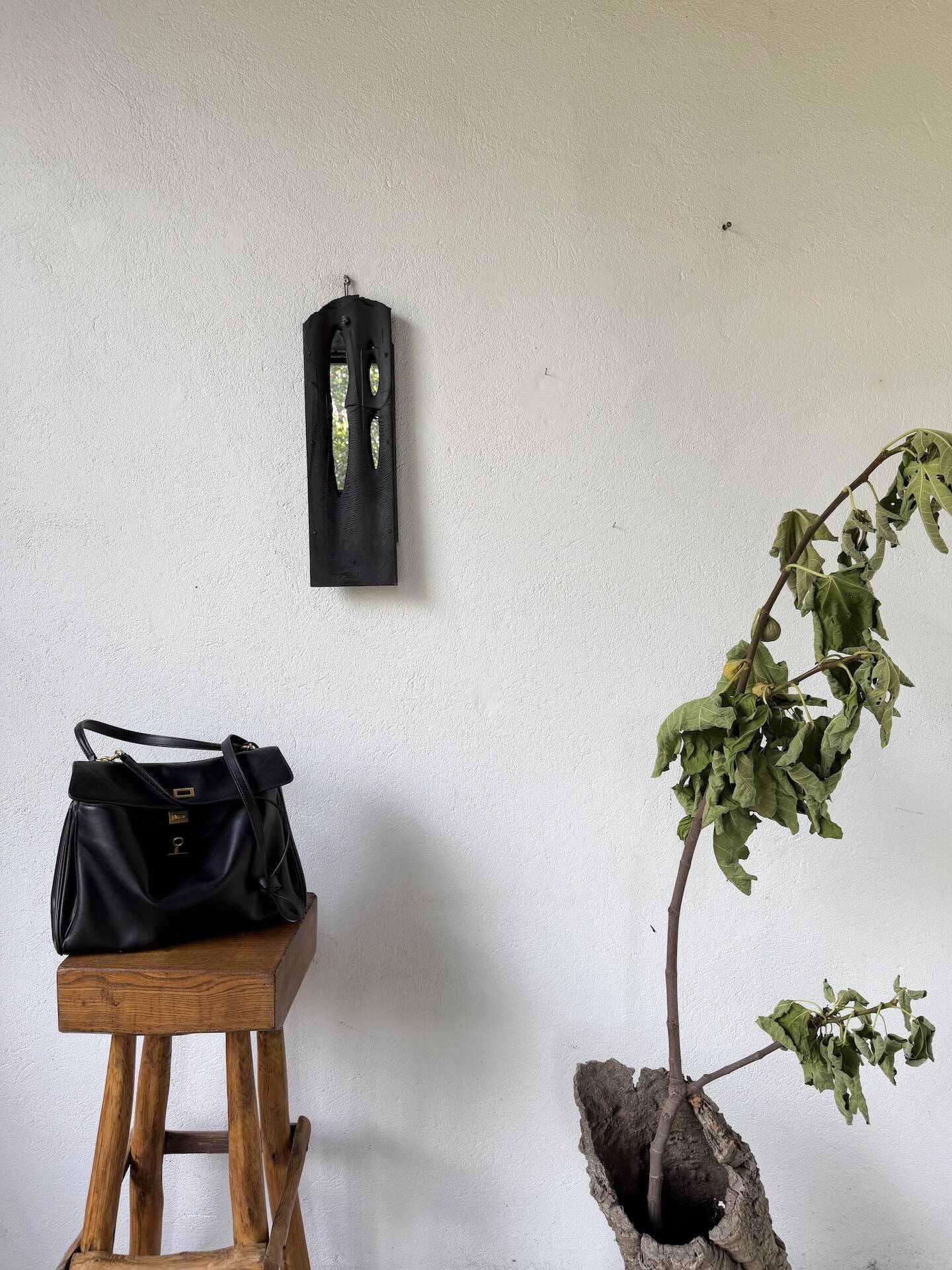 Brutalist hammered mirror, free-form, patinated metal.