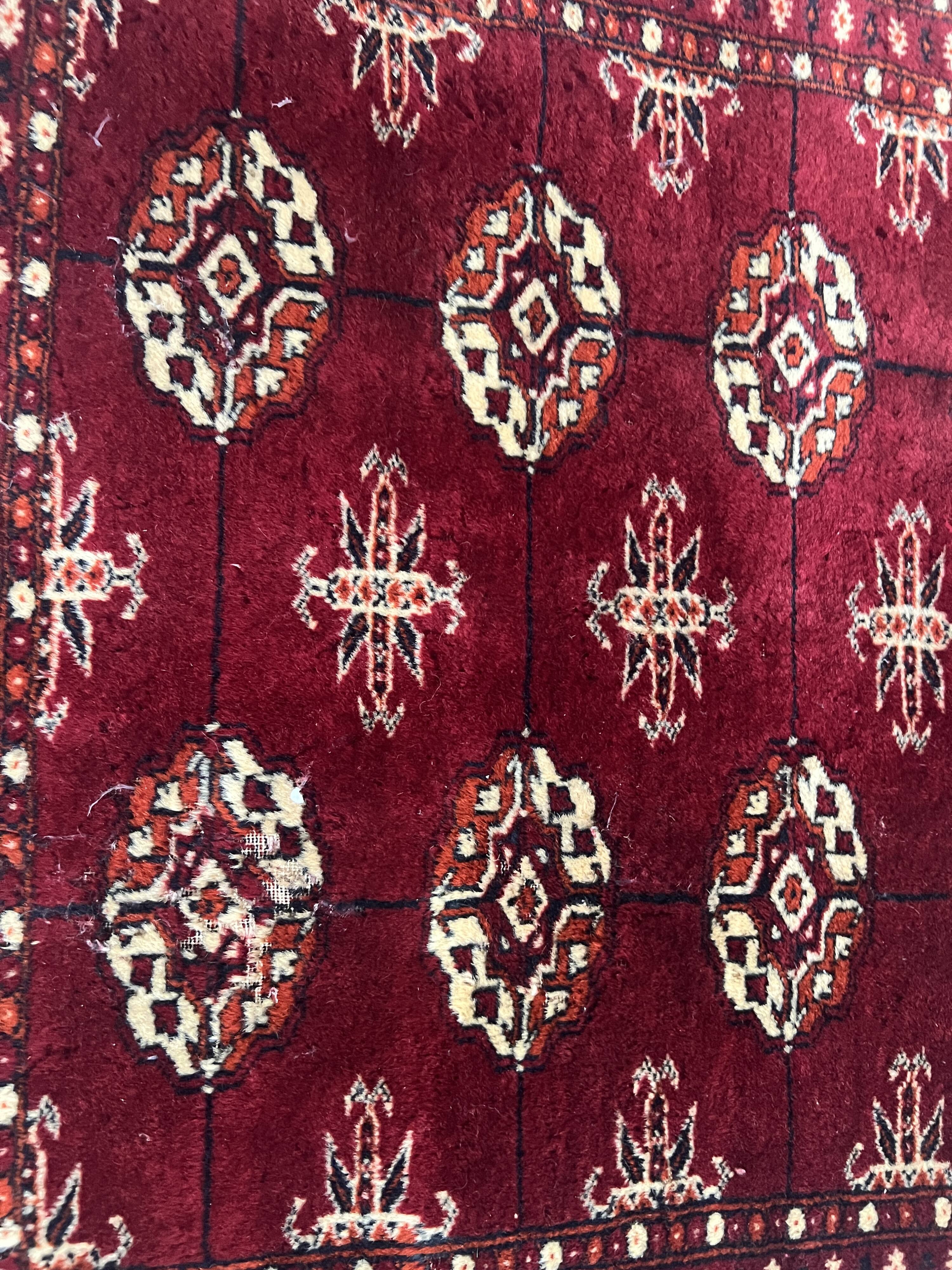 Antique wool rugs with designs on a red background, 20th century.