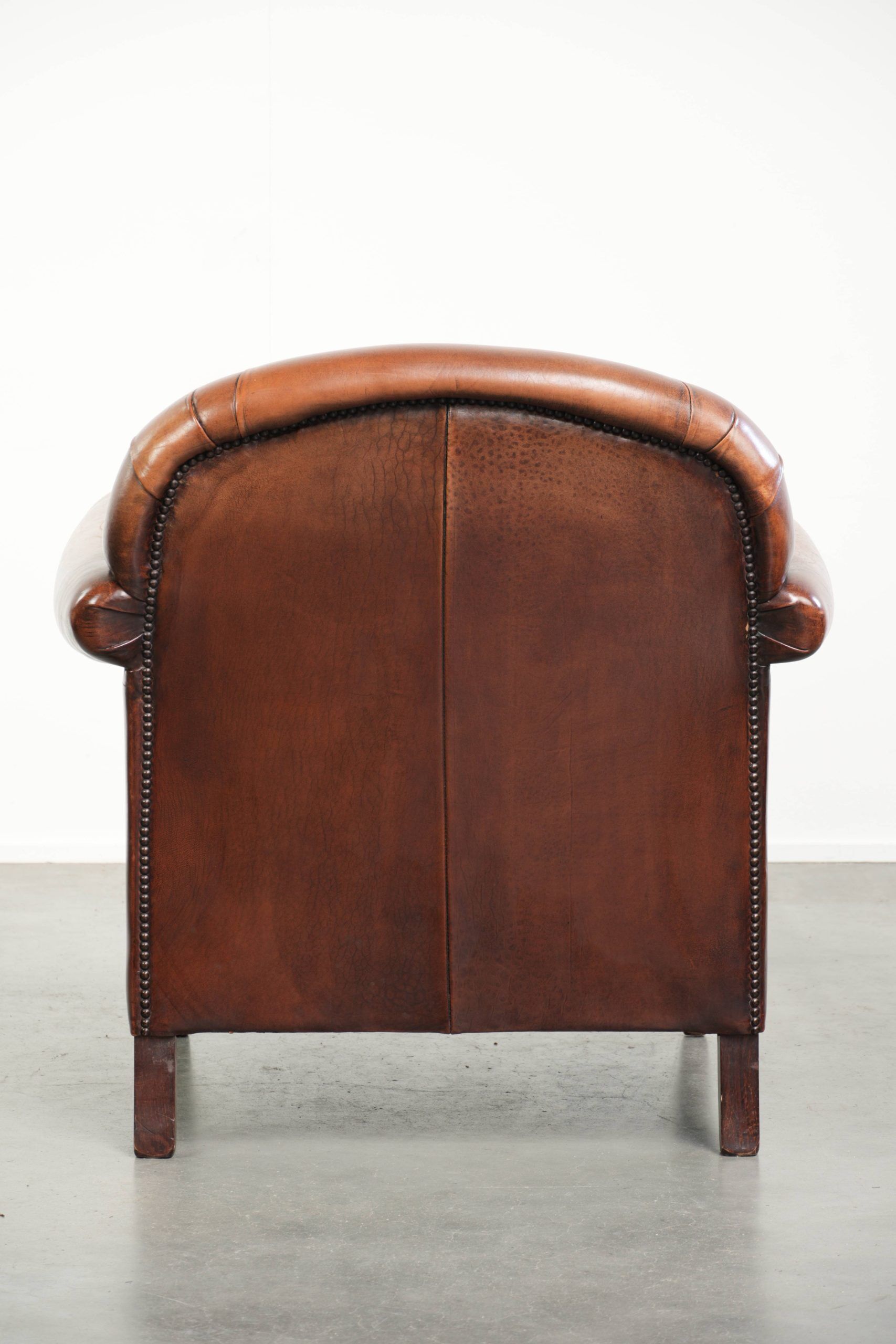 Sheepskin armchair with comfortable seat and finished with decorative nails