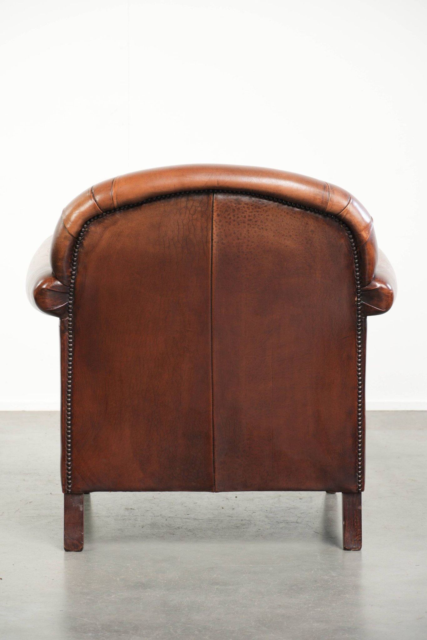 Sheepskin armchair with comfortable seat and finished with decorative nails