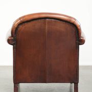 Sheepskin armchair with comfortable seat and finished with decorative nails