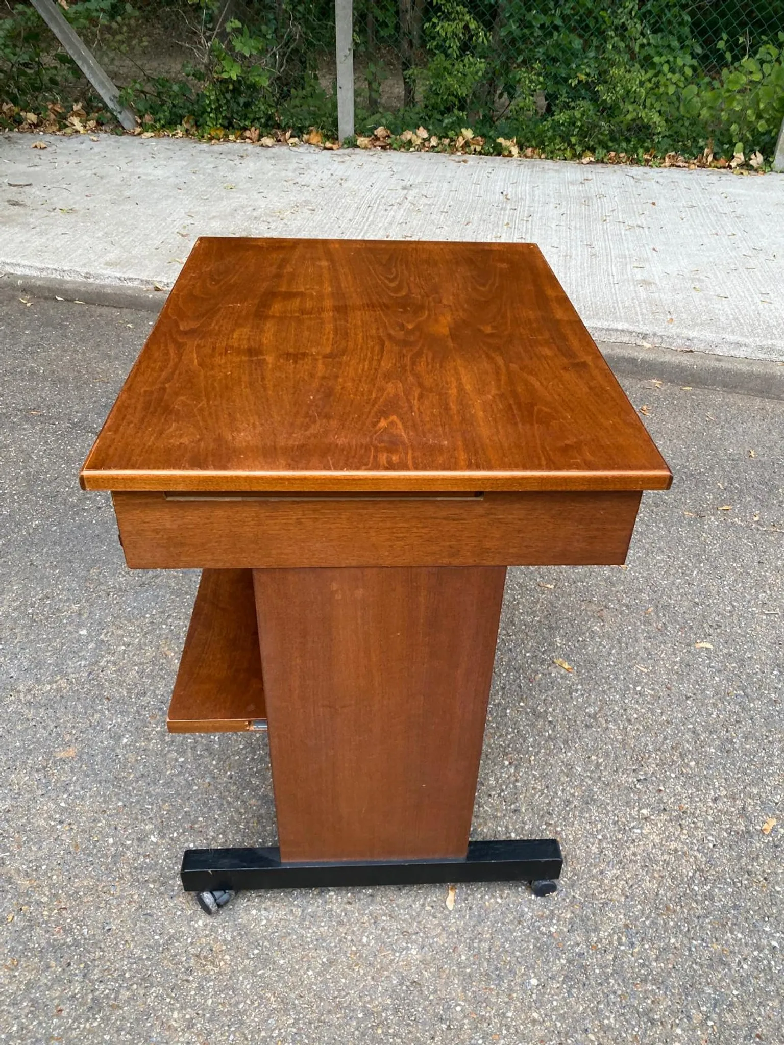Small Scandinavian-style computer desk on wheels made of wood.