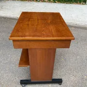 Small Scandinavian-style computer desk on wheels made of wood.
