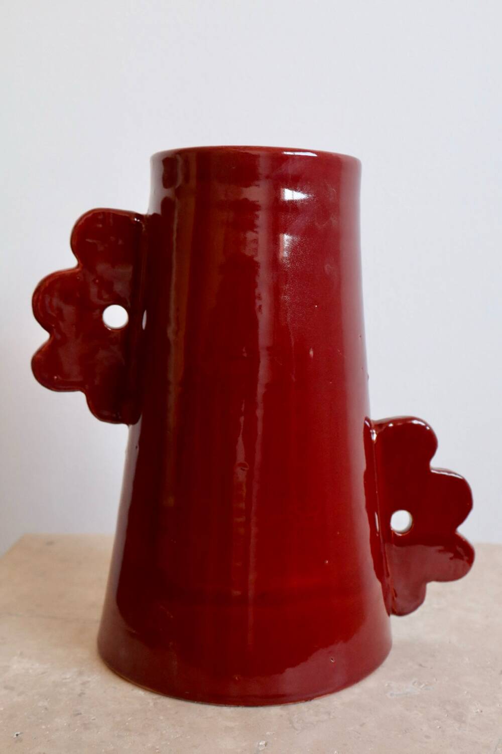 Handmade abstract ceramic vase with asymmetrical handles and burgundy flower