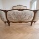 Double bed in Louis XVI style made of wood and floral fabric.