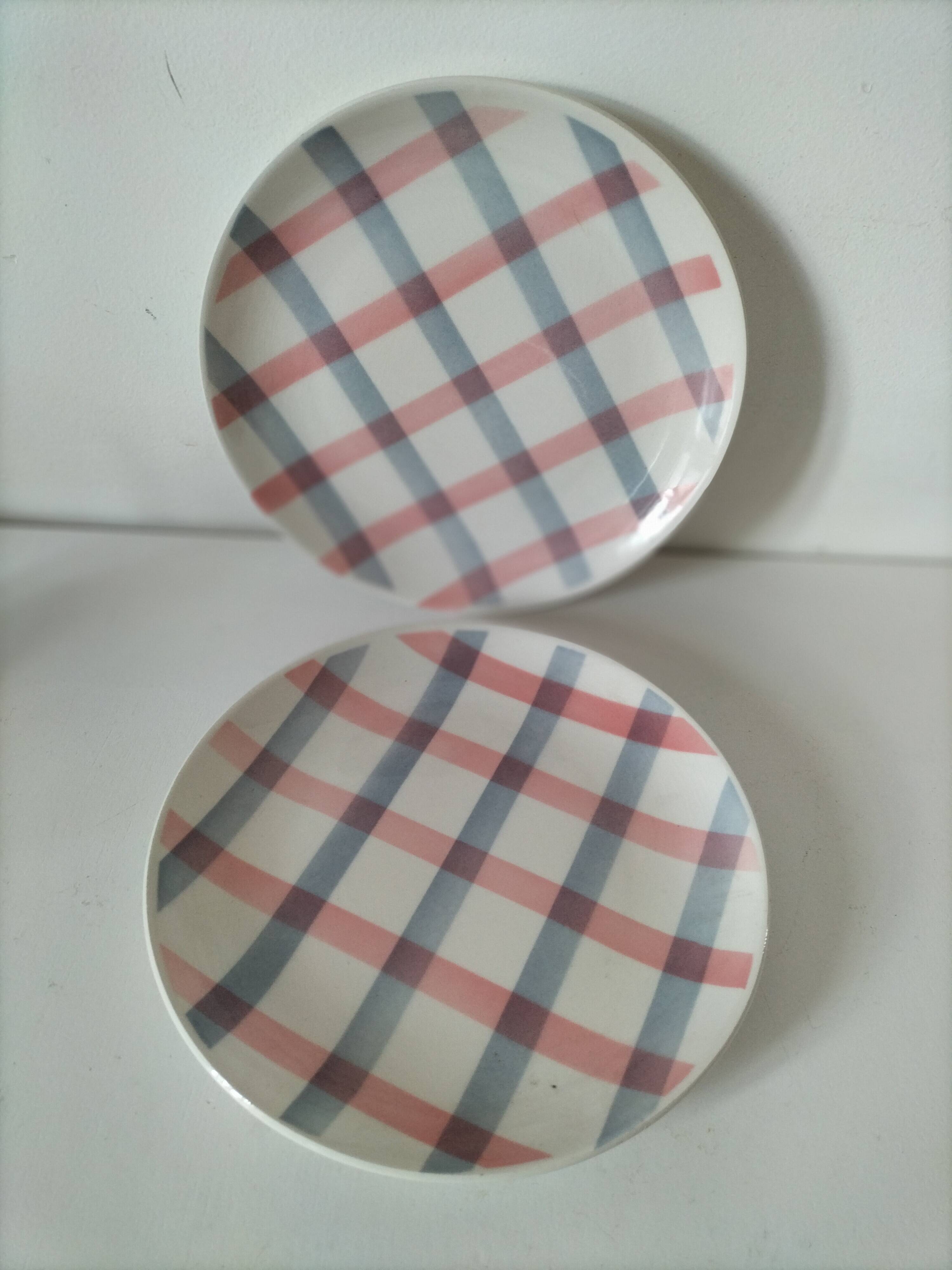 Two dessert plates Moulin des Loups with a pink and grey tablecloth design.