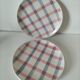 Two dessert plates Moulin des Loups with a pink and grey tablecloth design.