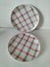 Two dessert plates Moulin des Loups with a pink and grey tablecloth design.
