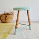 Antique tripod stool with striped seat.