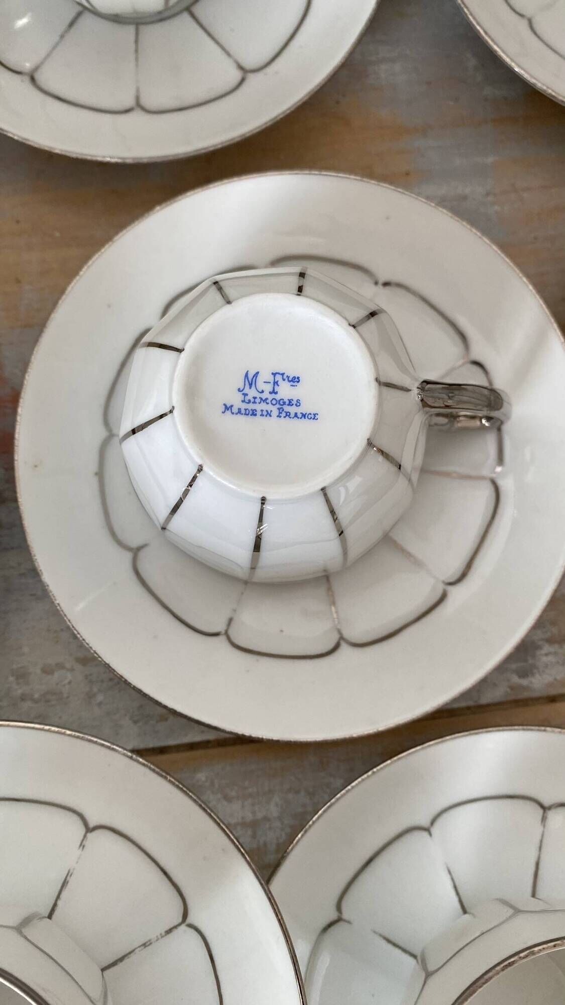 White and silver Limoges porcelain coffee cups and saucers.