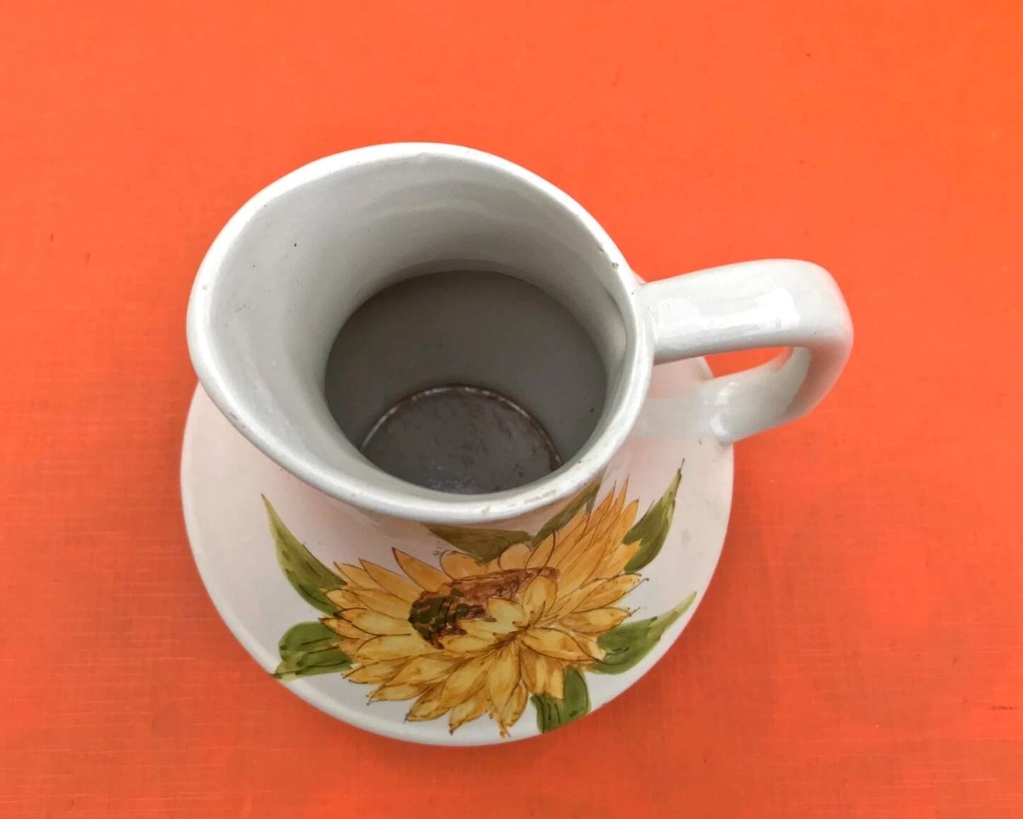Antique glazed ceramic pitcher with sunflower decoration