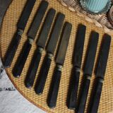 A set of 8 knives with black wooden handles