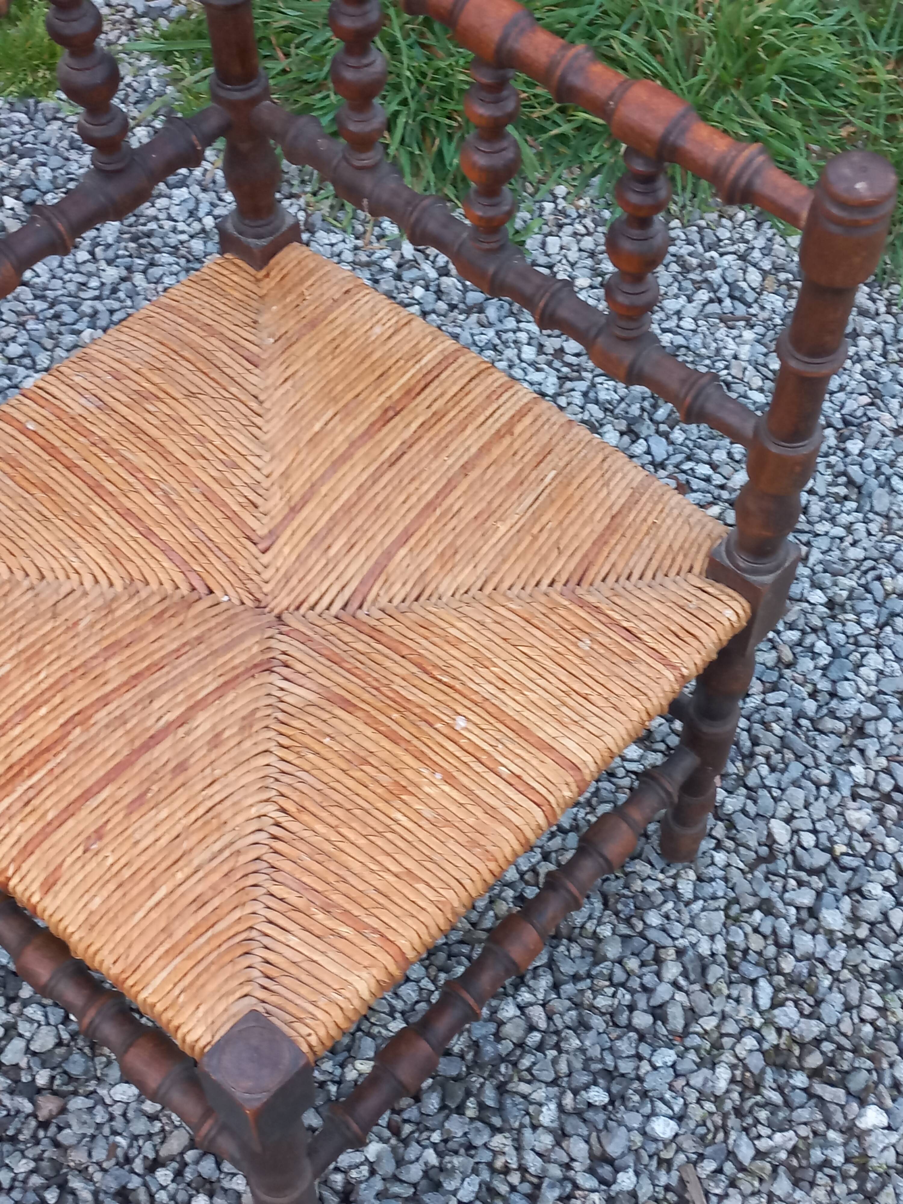 Pair of angled armchairs with turned wood and rush seats from the 1960s.