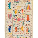 White suzani kilim rug with embroidered colorful patterns