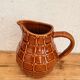 Vintage Saint Clément pitcher with a caramel checkered design.