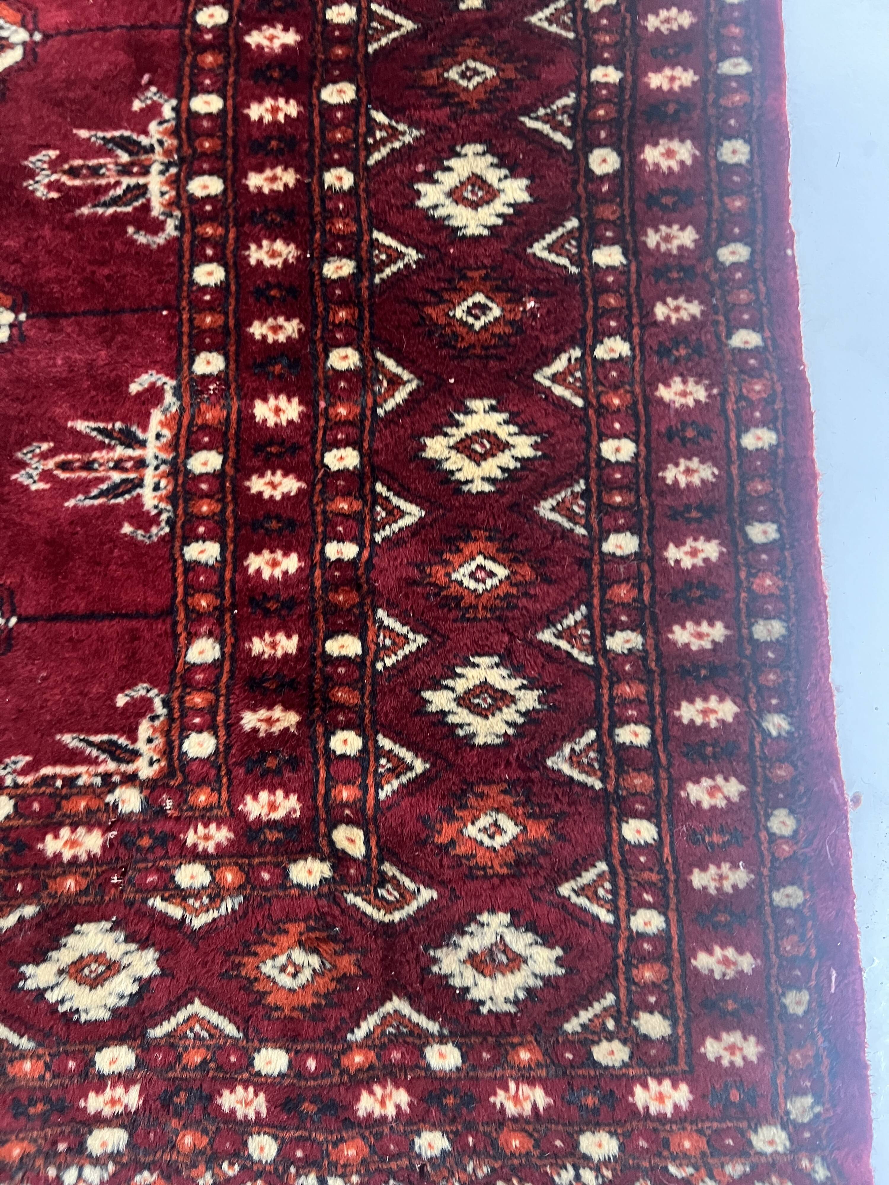 Antique wool rugs with designs on a red background, 20th century.