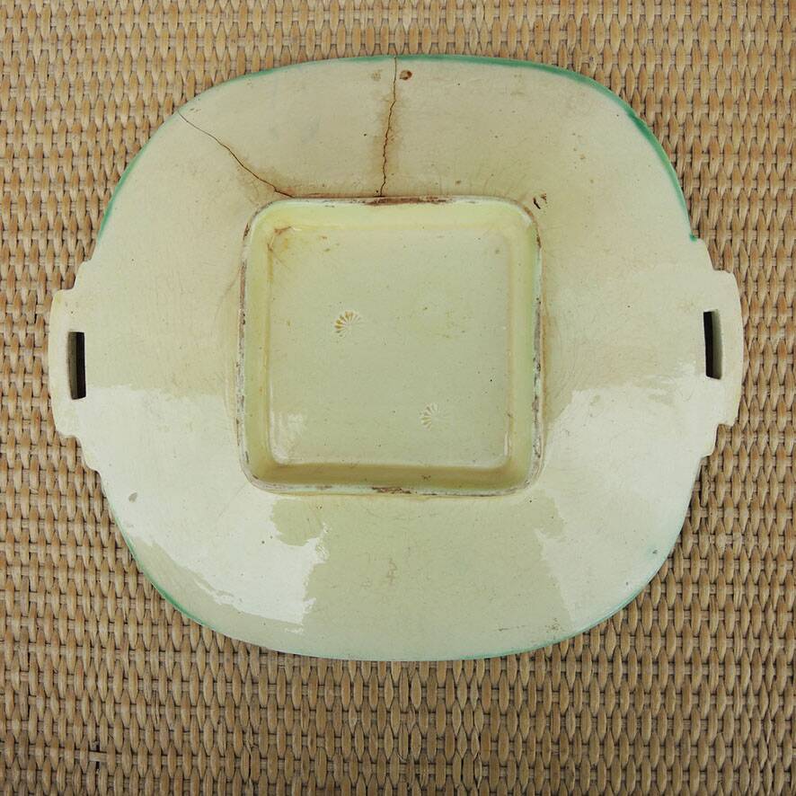 Old square plate in slipware with plant decoration.