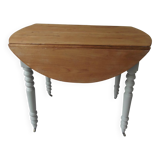 Walnut table with raised flaps, base on verdigris casters.