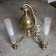 Brass chandelier with three flames.