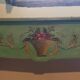Old green wooden console with floral patterns.