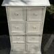 Small antique workshop cabinet with 8 painted wooden drawers.