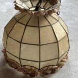 Vintage pendant light with a pearlescent shade and floral decoration.
