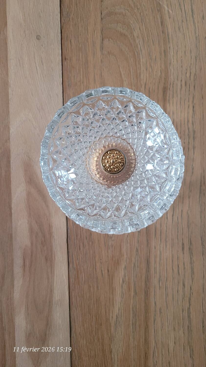 Two-tier display stand in cut glass mounted on a gold metal base.