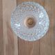 Two-tier display stand in cut glass mounted on a gold metal base.