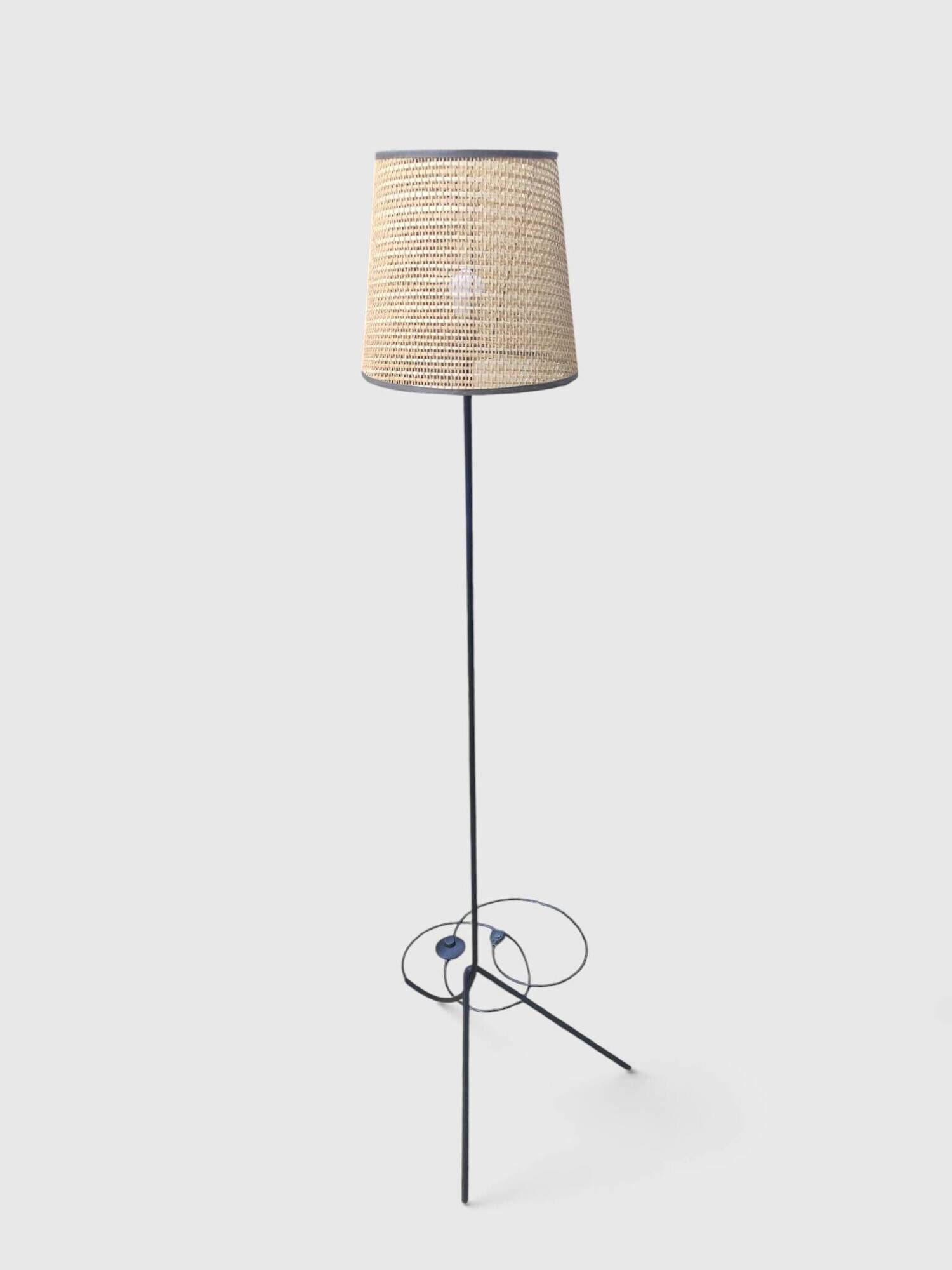 Modernist tripod floor lamp in black metal and cane from the 1950s/1960s.