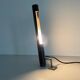 Minimalist black metal wall light with a cylindrical design, 1960s, Germany.