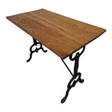 Solid oak bistro table with a cast iron base, signed.