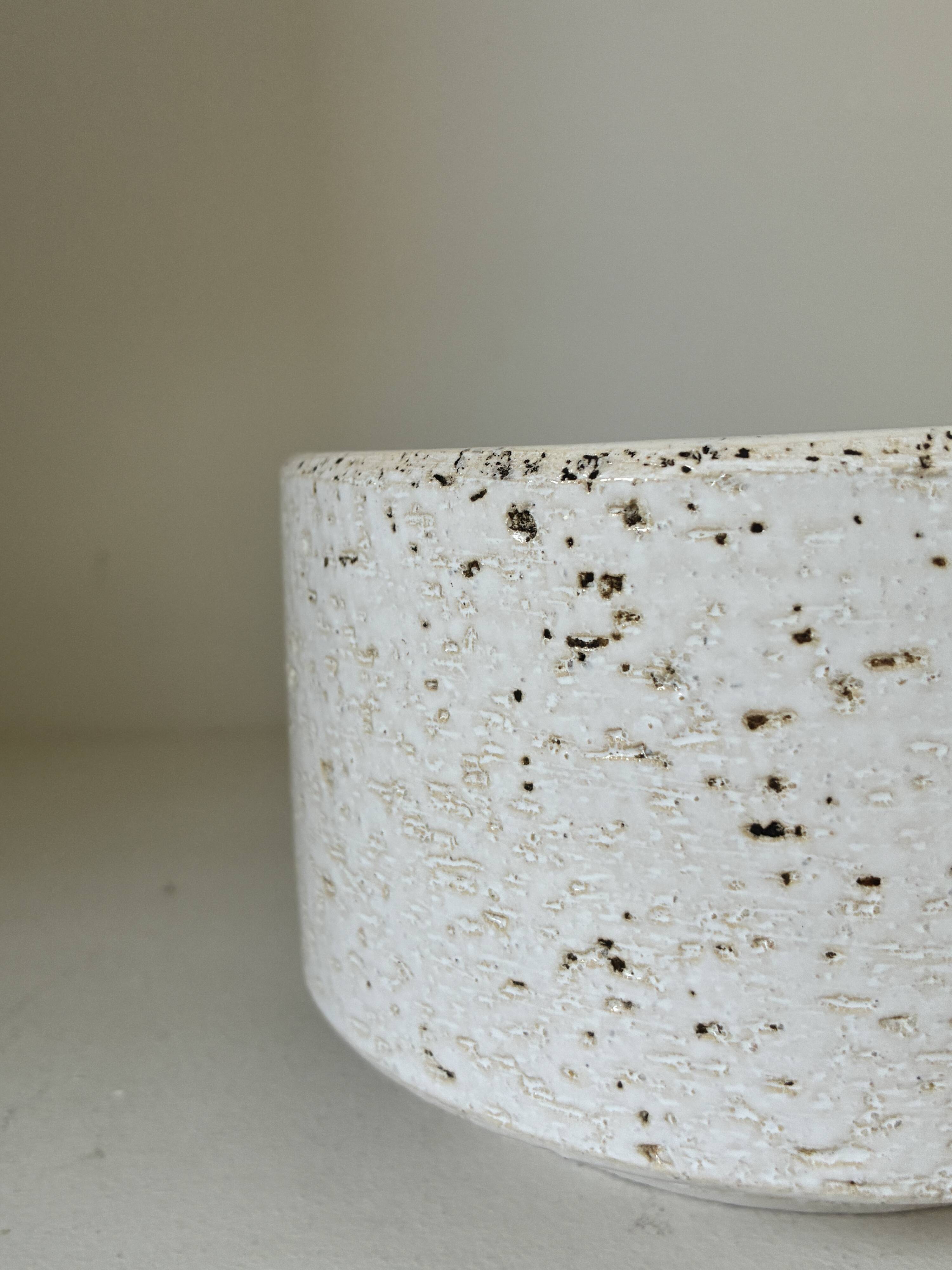 White ceramic vase with a textured effect.