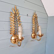 Pair of Italian wall sconces in gilded metal, Hollywood Regency style, 1970.