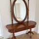 Traditional wooden dressing table with oval mirror.