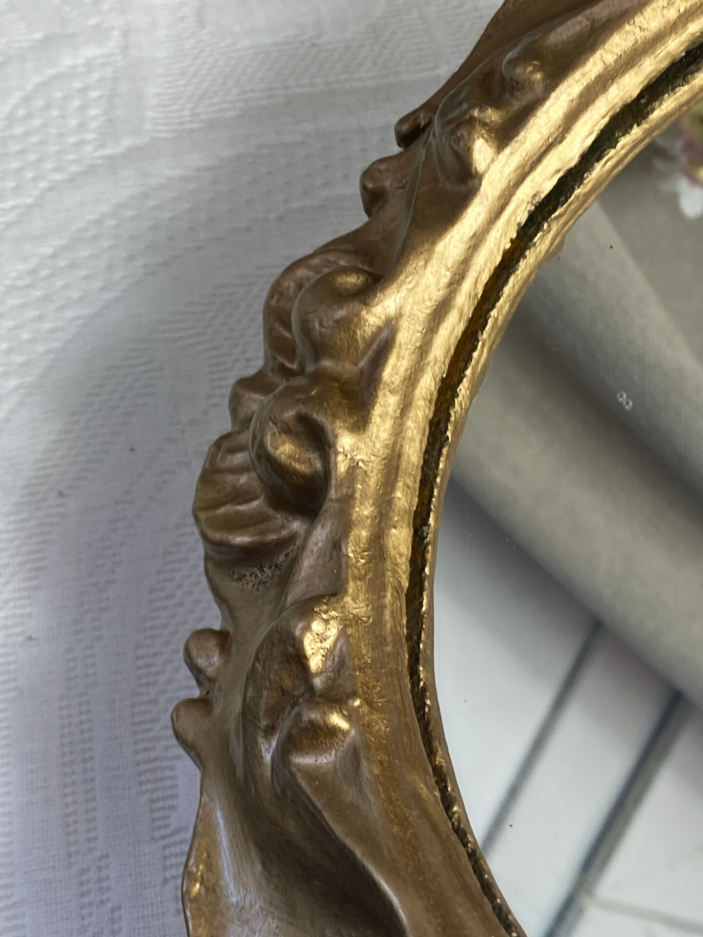 Round wooden mirror in golden colour.
