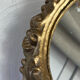 Round wooden mirror in golden colour.