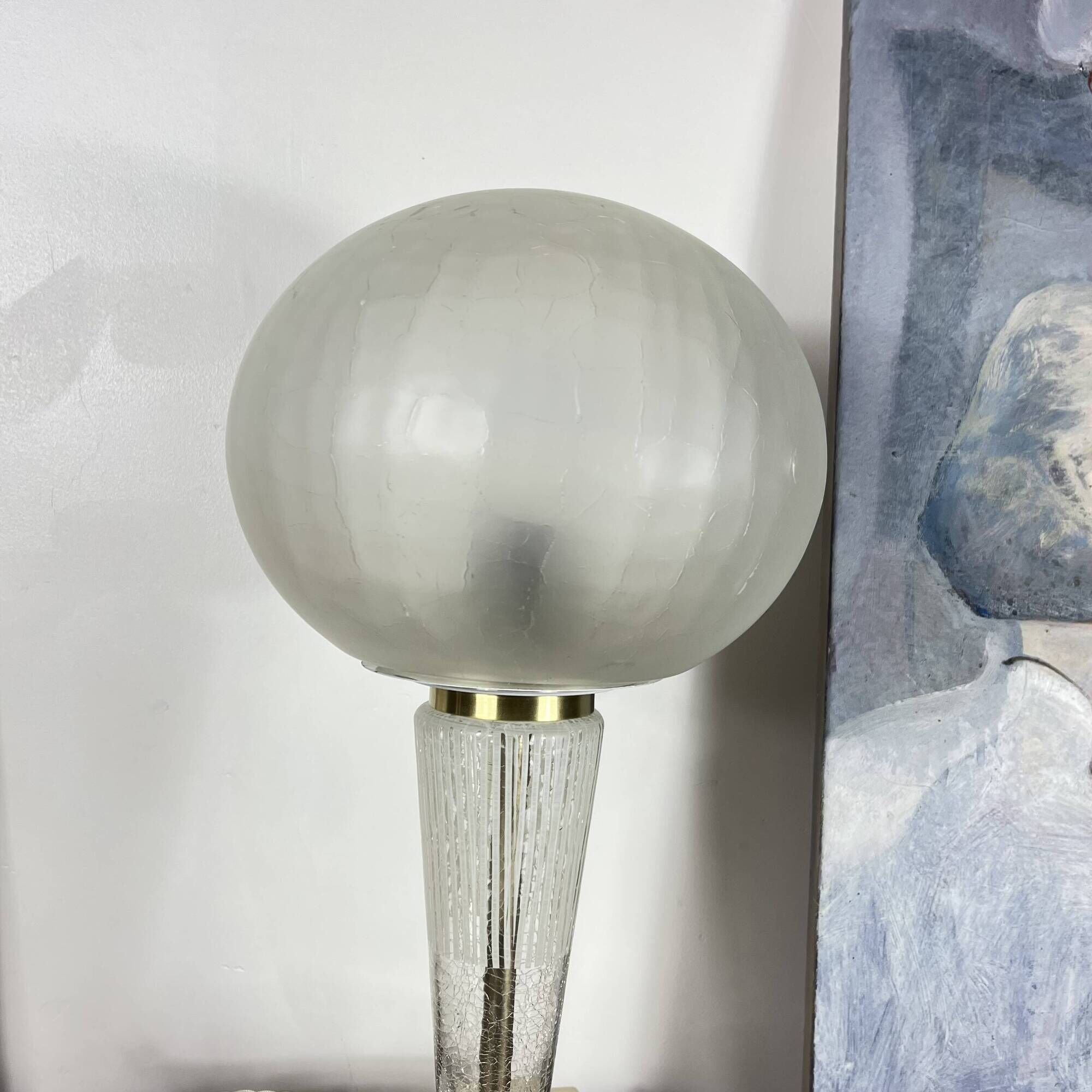 Large globe table lamp with a cracked glass base and brass stand.