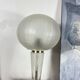 Large globe table lamp with a cracked glass base and brass stand.