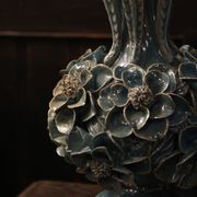 Une paire de lampes bleu clair iridescentes, avec un design de buisson floral.