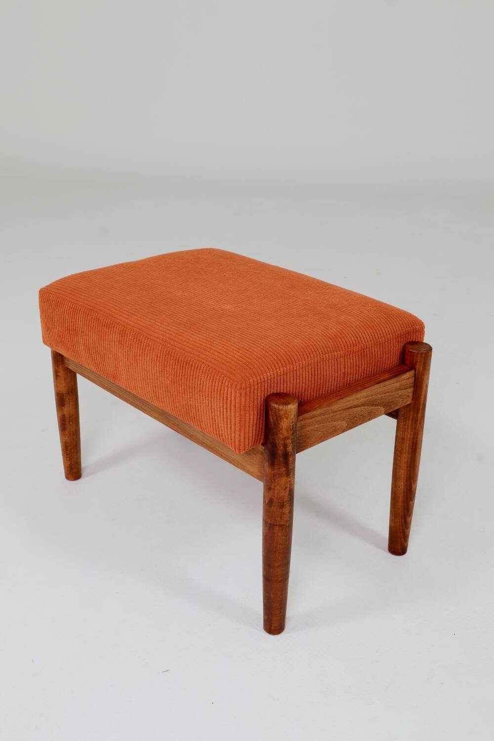Vintage armchair and footrest in orange corduroy.