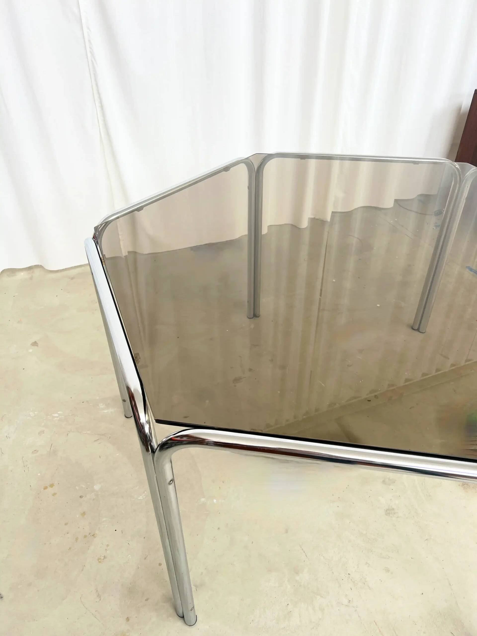 Vintage hexagonal table with smoked glass top and chrome metal structure.