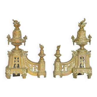 Pair of gilded brass fire dogs decorated with fire pots in the Louis XVI style.