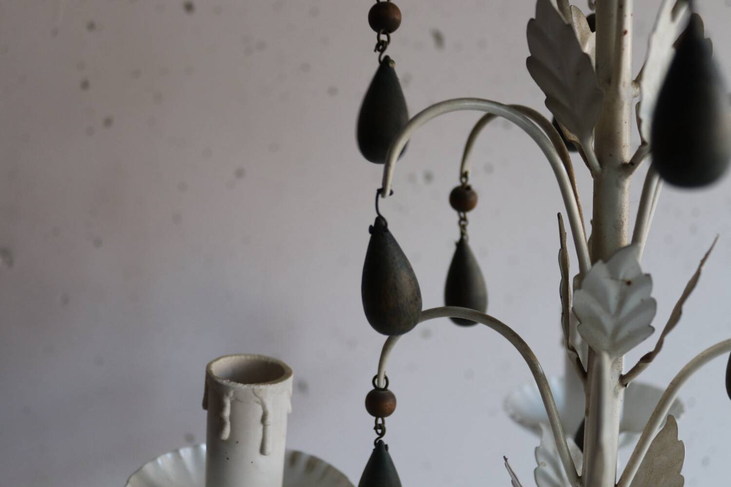 Antique white lacquered metal chandelier with wooden pendants.